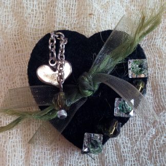 BlackFabricHeart-Metal-Green-Ornament. Χειροποίητη καρφίτσα Cosa Nostra από τσόχινη βάση-καρδιά κεντημένη στο χέρι με μεταλλικό στοιχείο-καρδιά, χάντρες, αλυσίδα νίκελ, οργάντζα και Swarovski. Διαστάσεις: 4cm x 3cm.