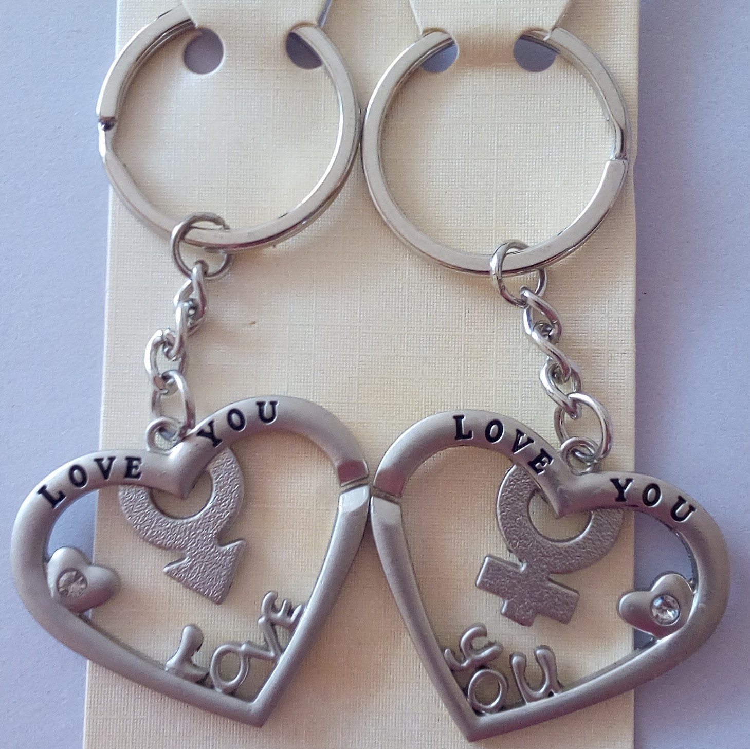 Διπλό μπρελόκ από ανοξείδωτο ατσάλι καρδιές-σήμα θηλυκού/αρσενικού και τη φράση “Love you” σε εγχάραξη. Δύο μπρελόκ σε σχήμα καρδιάς με το σήμα θηλυκού-αρσενικού και στρας. Διαστάσεις: συνολικό ύψος 8cm, στοιχείο 3.5cm x 4cm.