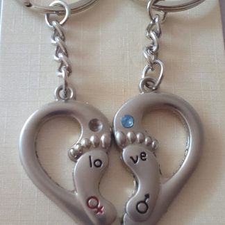 Διπλό μπρελόκ από ανοξείδωτο ατσάλι καρδιά-πατουσάκια. Δύο μπρελόκ που αποτελούν μαζί μία καρδιά και το καθένα έχει πατουσάκι με το σήμα θηλυκό-αρσενικό και ζιργκονάκι ροζ ή γαλάζιο. Διαστάσεις: συνολικό ύψος 9cm, στοιχείο 4cm x 2cm.