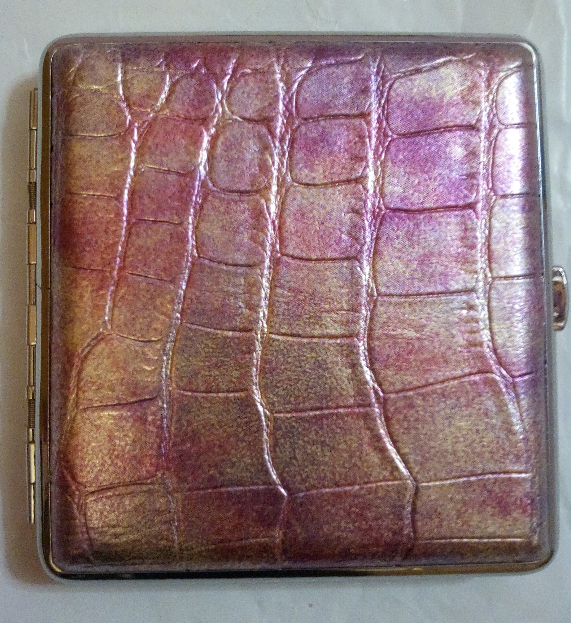 Ροζ μεταλλική ταμπακιέρα, ντυμένη εξωτερικά με δερματίνη. Διαστάσεις: ύψος 9cm x μήκος 9.5cm - 8.5cm για τσιγάρο.