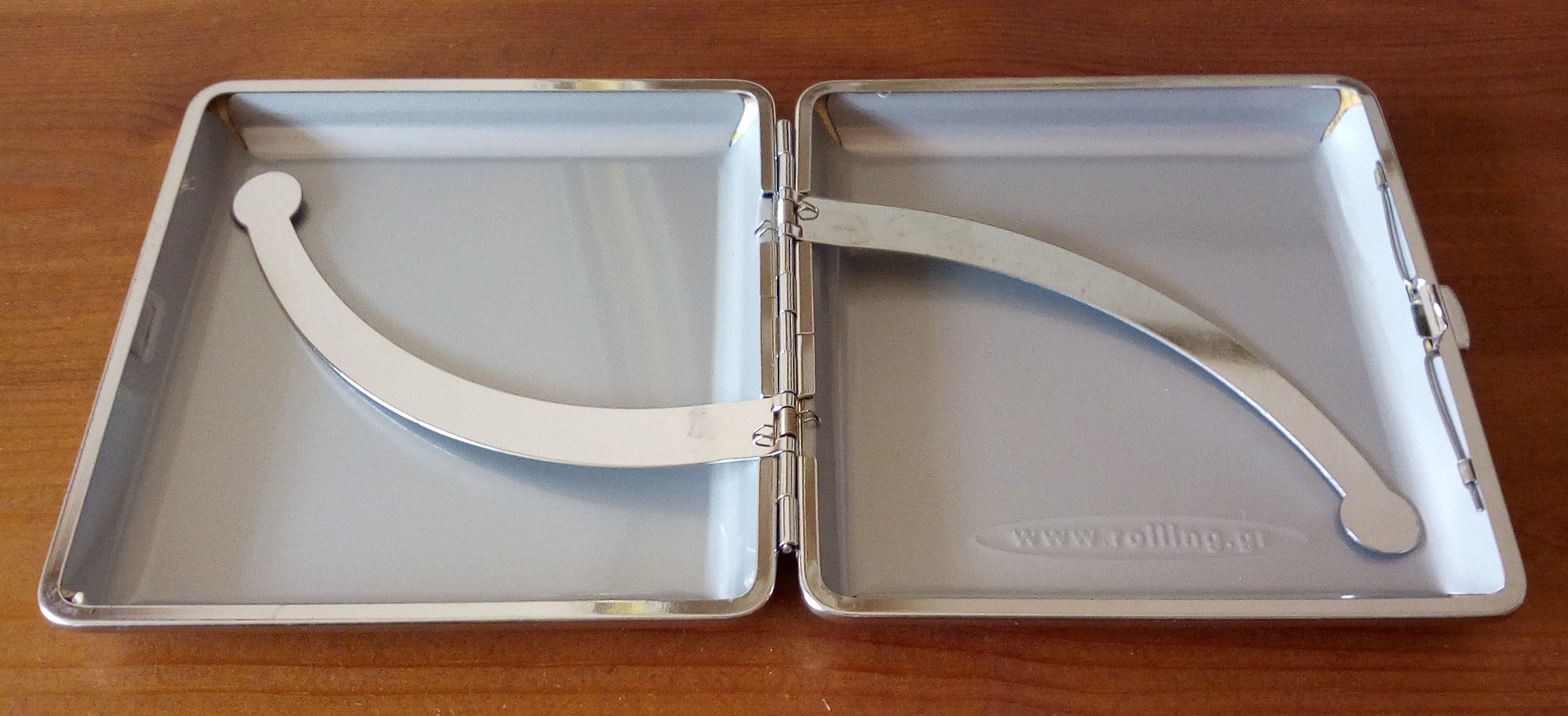 Ροζ μεταλλική ταμπακιέρα, ντυμένη εξωτερικά με δερματίνη. Διαστάσεις: ύψος 9cm x μήκος 9.5cm - 8.5cm για τσιγάρο.